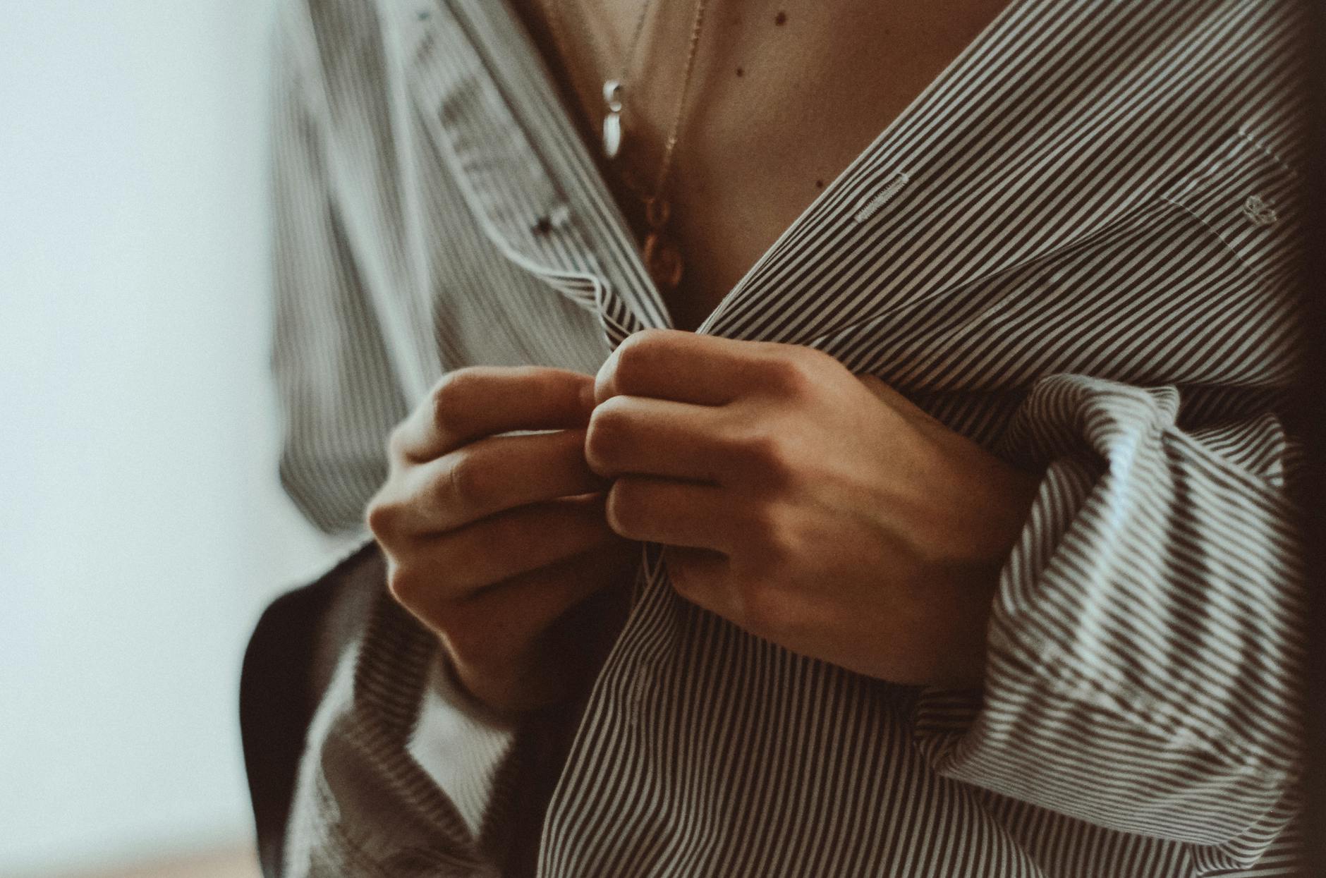 Stock CU photo of a shirt button either being done up or undone from Pexels.com 