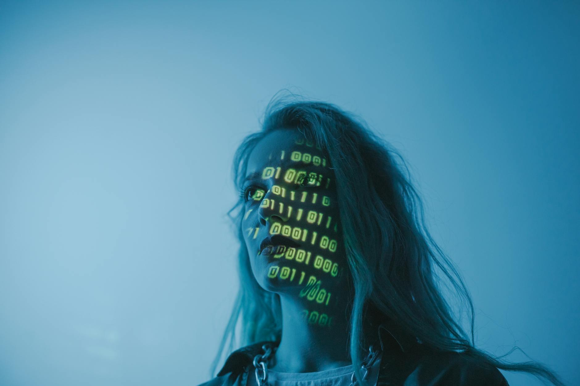 Stock photo of a human face with computer code projected on it from Pexels.com