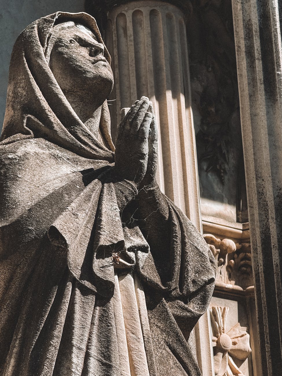 Stock photo of a statue of an archaic human striking a prayerfully pose from Pexels.com  