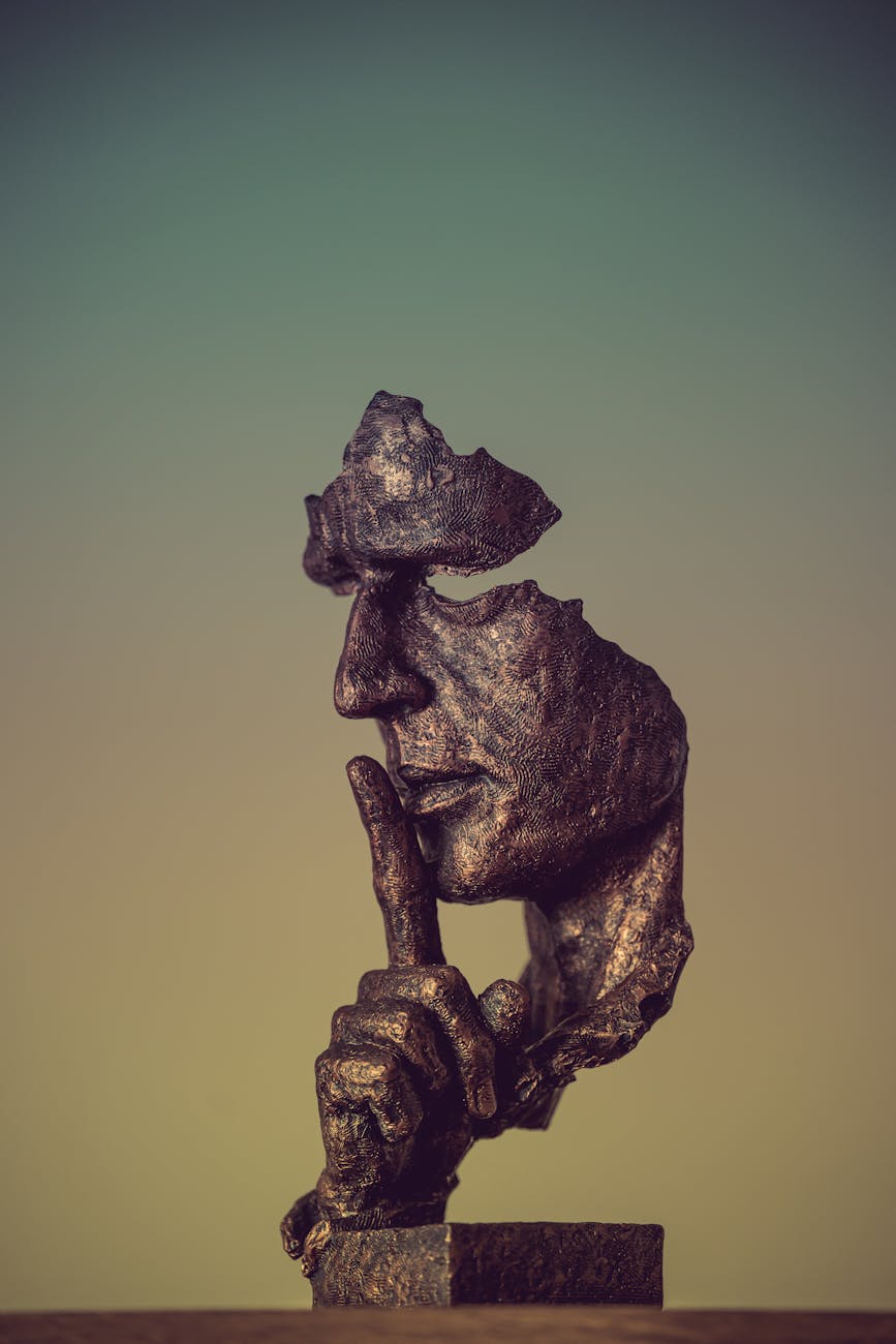 Stock photo of a statue of a fragmented human face holding their forefinger up to their lips in a frozen shhh from Pexels.com 