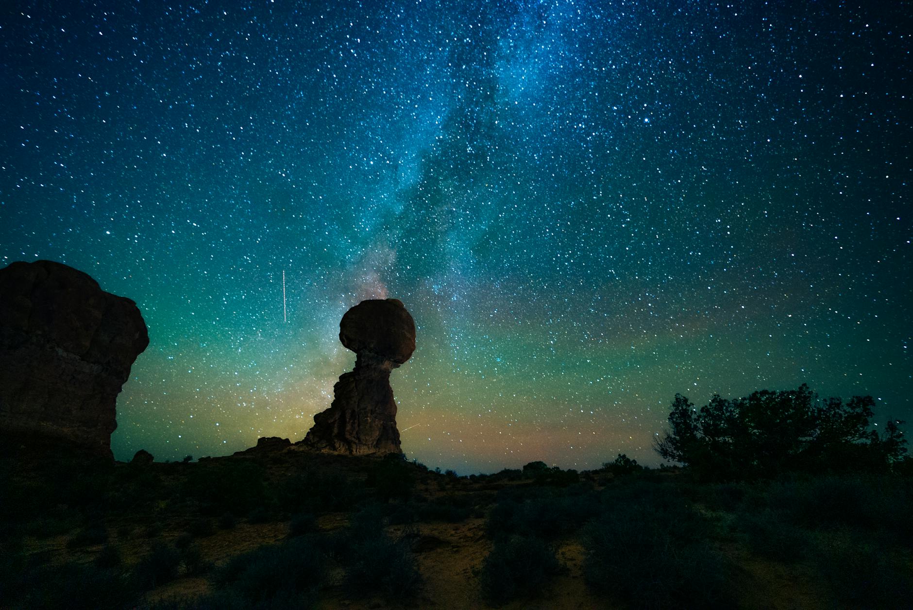 Stock photo of Milky Way as seen from the ground among rock formations on earth from Pexels.com