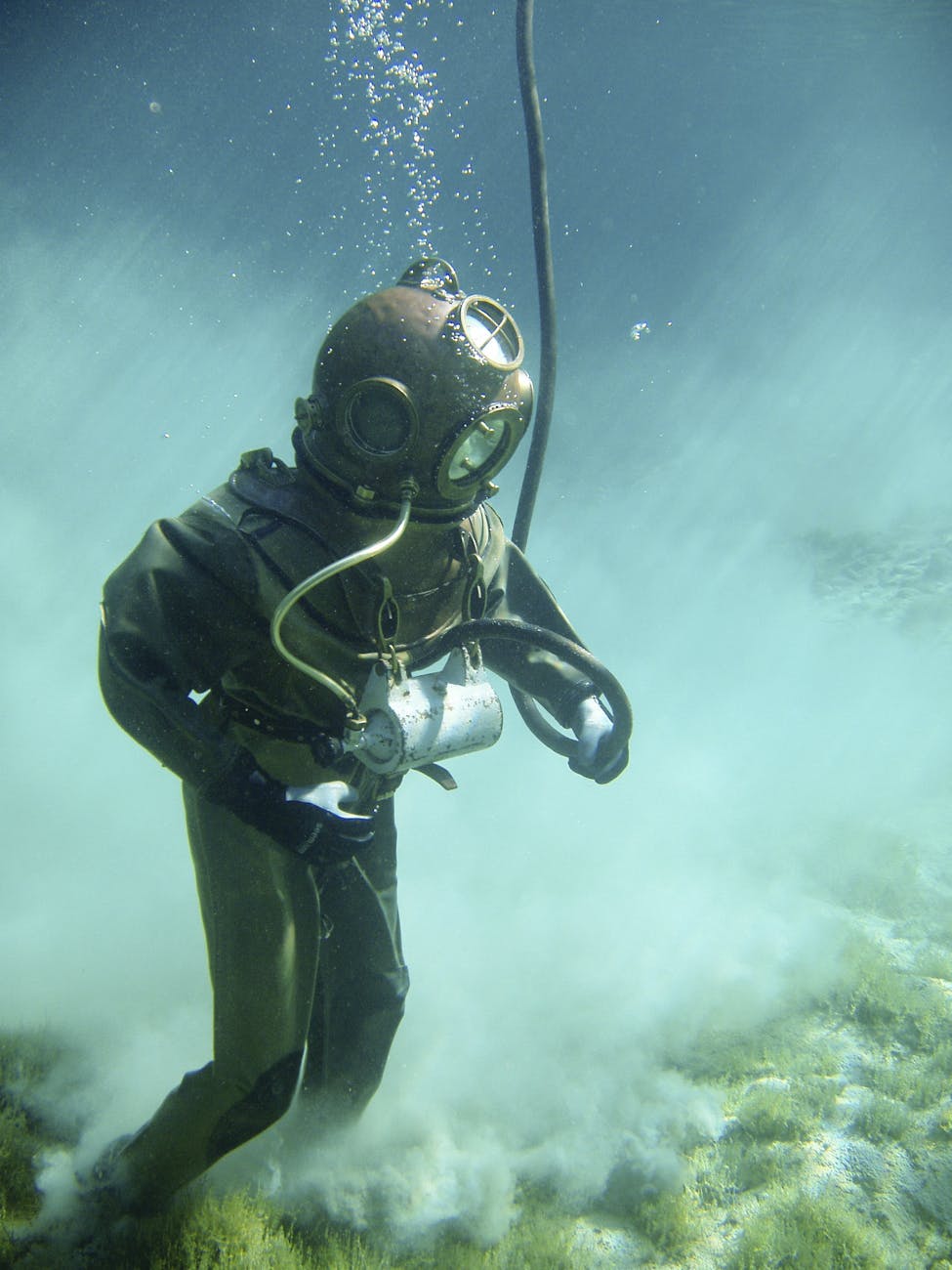 Stock photo of deep sea diver kicking up an obscuring cloud of silt walking on sea bottom from Pexels.com