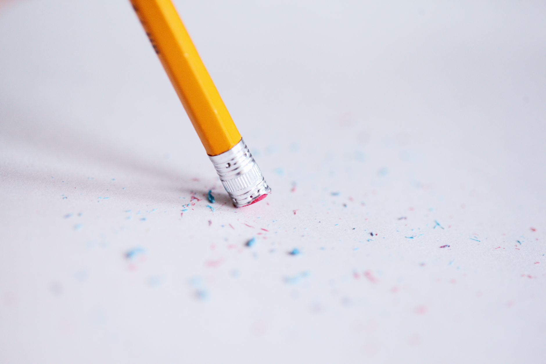 Stock photo of a worn down eraser on the end of a pencil with eraser crumbs left on the page from Pexel.com