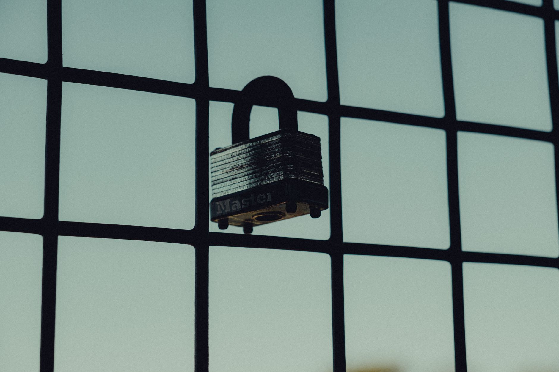 Stock photo of a padlock on a wire fence securing nothing from Pexels.com 