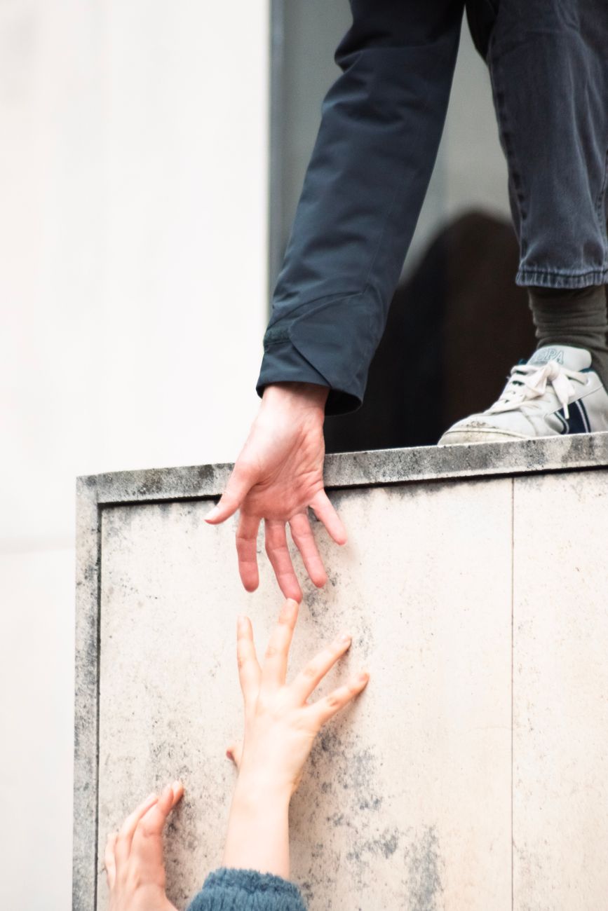 Stock photo of a hand reaching down from above to help a person up from Pexels.com