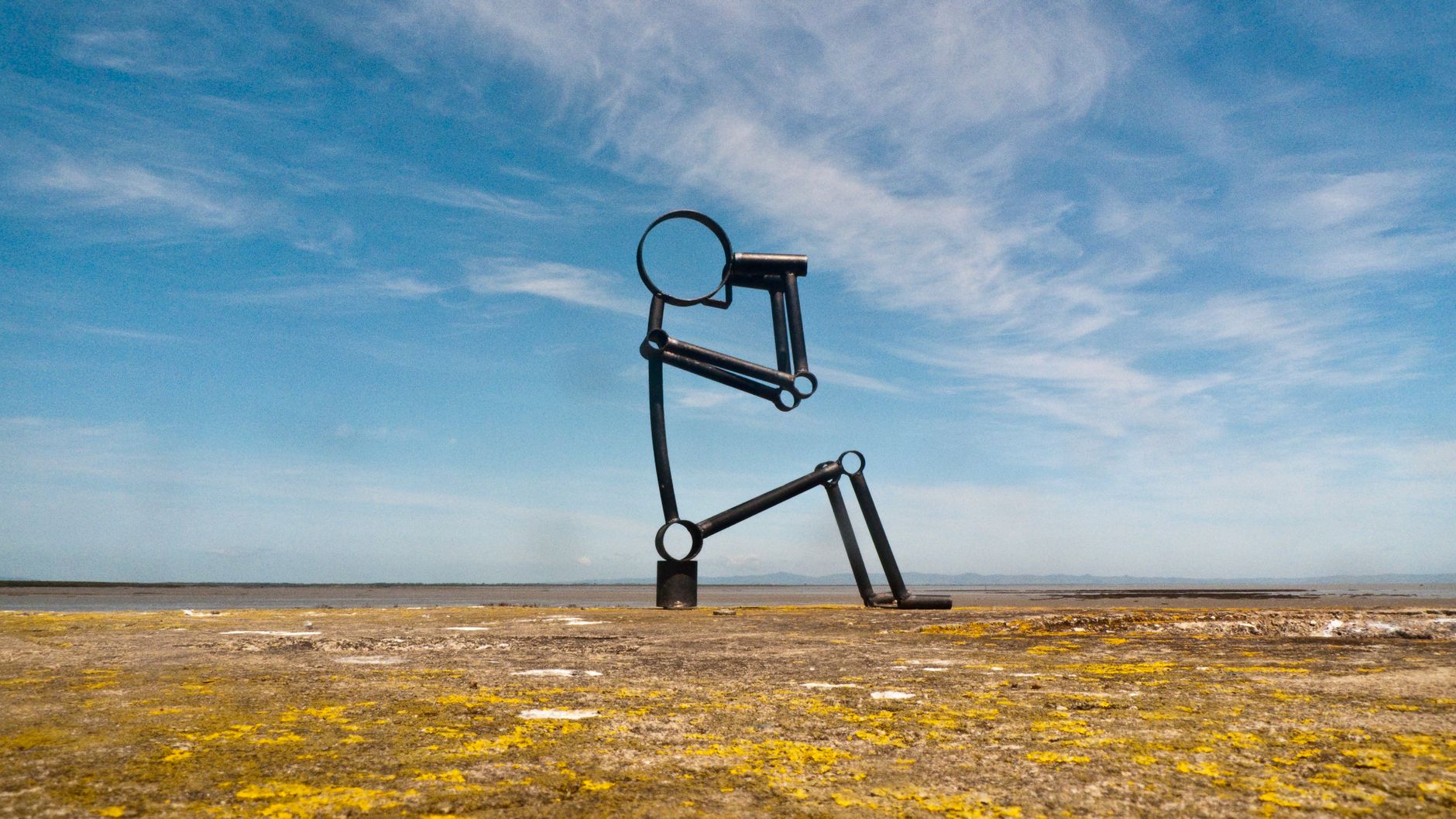 Stock photo shows "Exposure," a 26-meter-tall steel sculpture by Antony Gormley located on a dam in Lelystad, Netherlands. Nicknamed "The Crouching Man" because it represents a giant human figure crouching and gazing out at the water from Pexels.com 