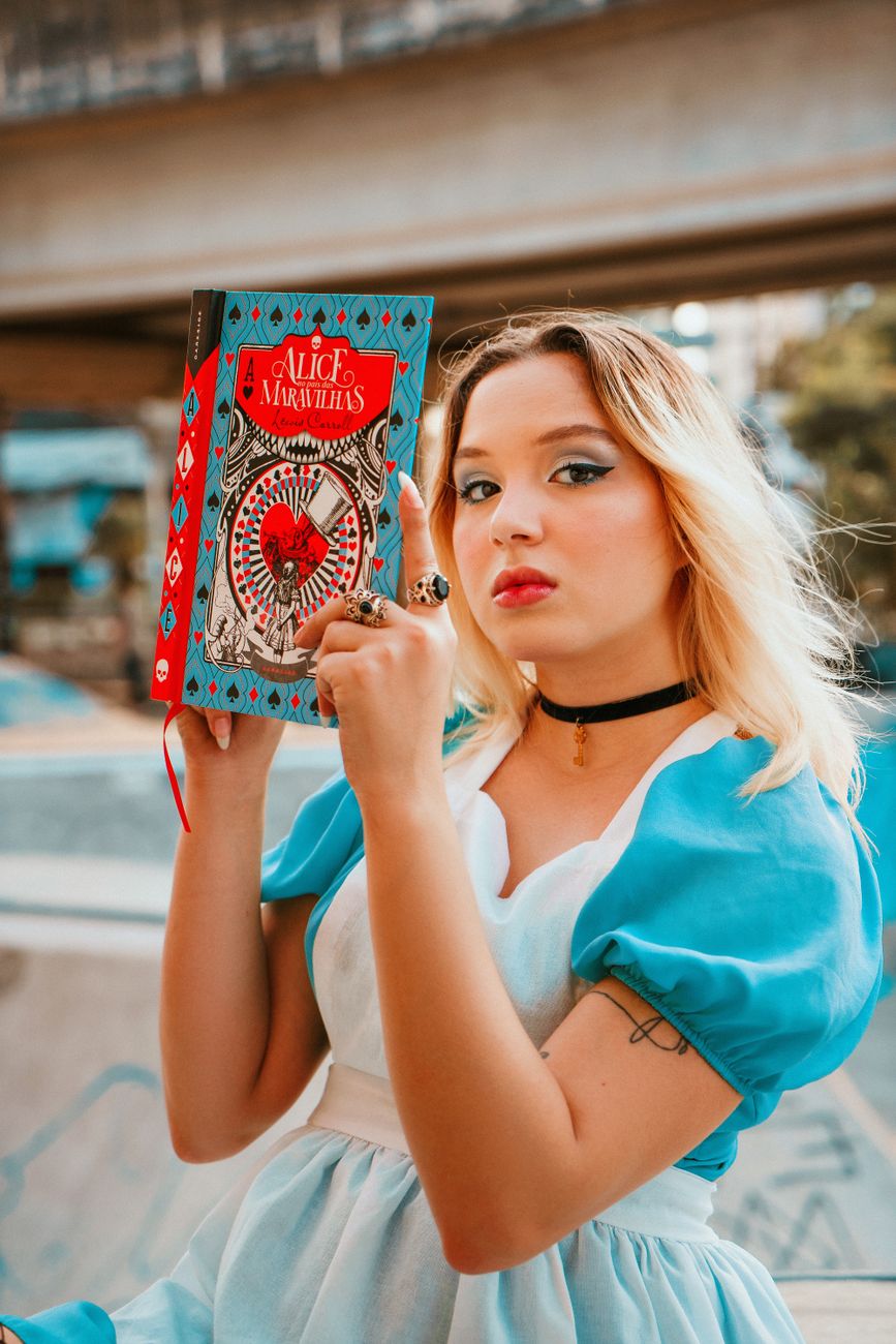 Stock photo of Alice reading her book about Wonderland from Pexels.com