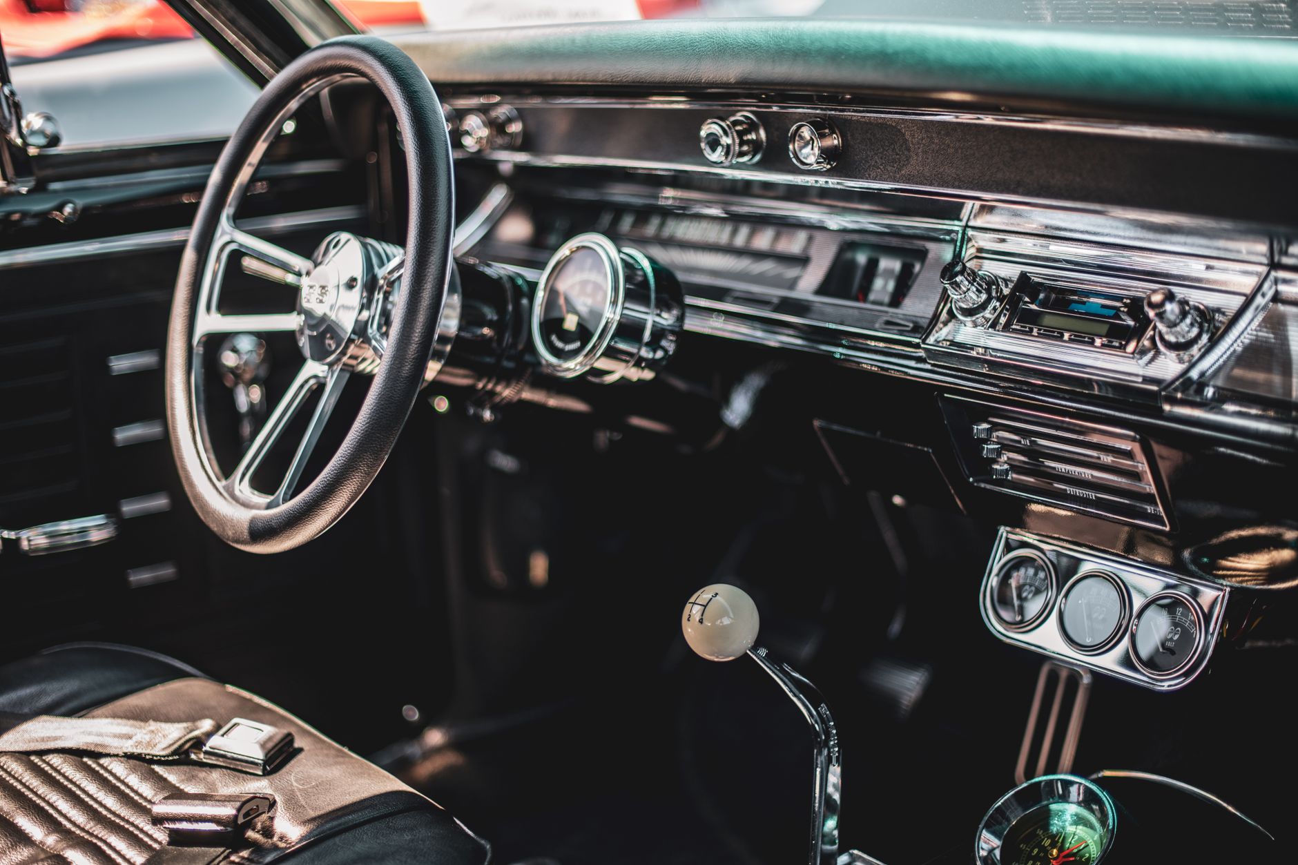 Stock photo of a classic interior vintage American muscle car, featuring a chrome steering wheel, a vintage dashboard, and a manual floor shifter from Pexels.com