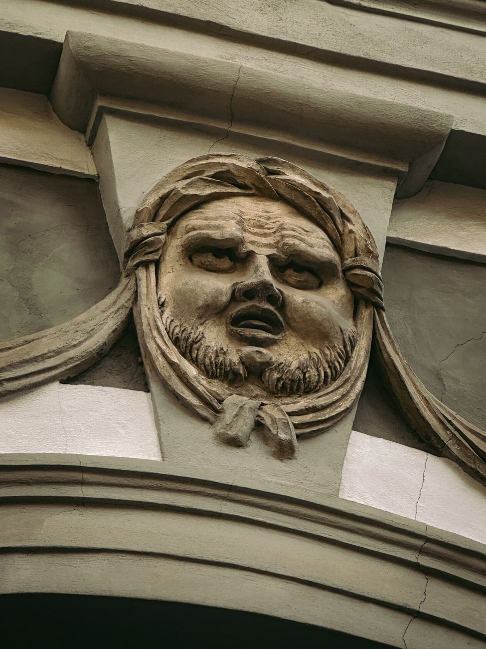 Stock photo shows a stone architectural face carved into a keystone from Pexels.com