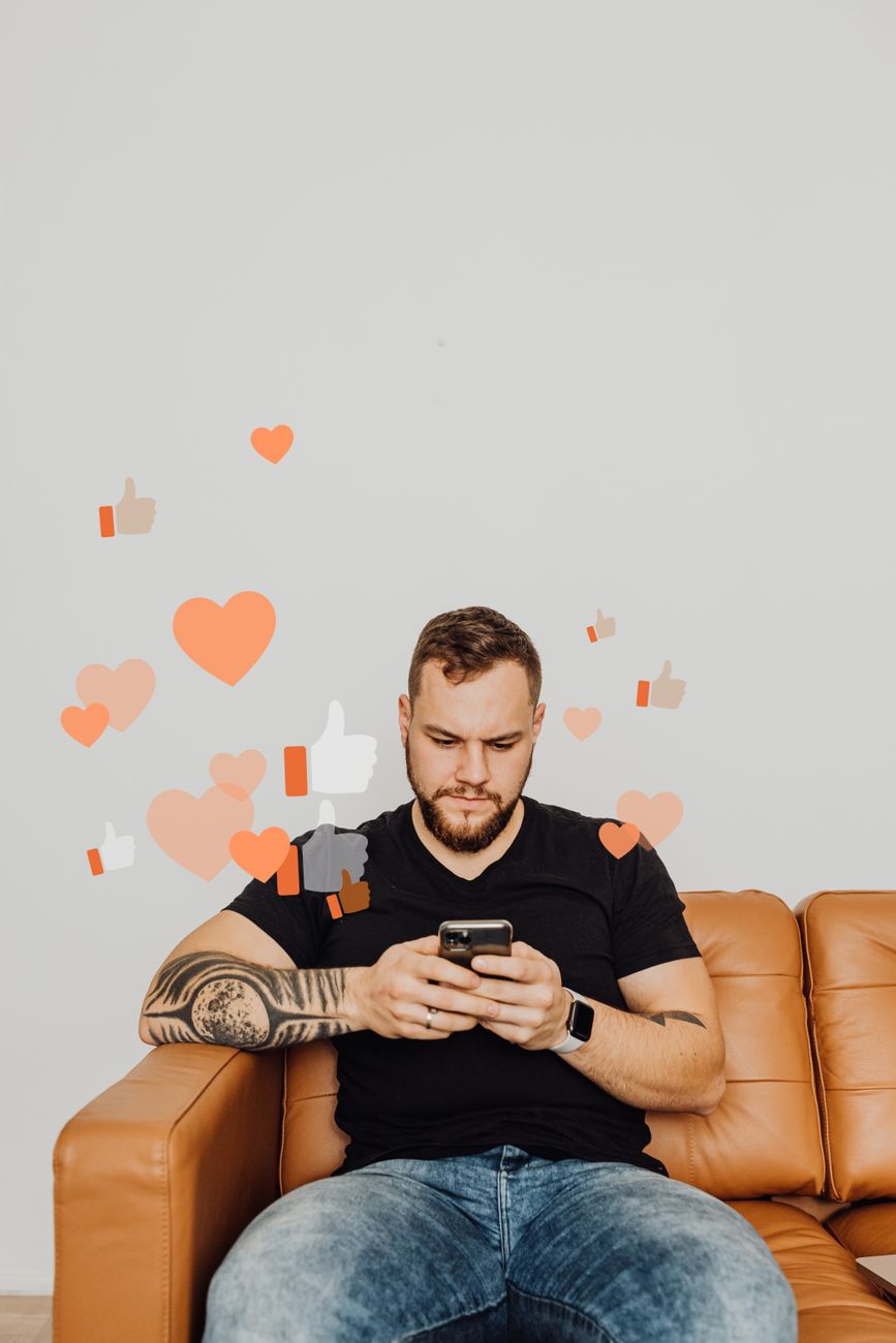 A stock photo showing a man sitting on a leather couch and using a smartphone, digitally overlaid with floating social media "like," "heart," and "thumbs-up" icons from Pexels.com
